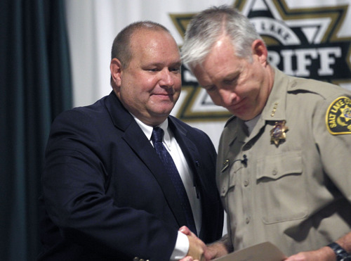 Al Hartmann  |  The Salt Lake Tribune  
Unified Police Detective Todd Park, left, shakes hands with Sheriff Jim WInder Wednesday July 18.  Park was recognized for his outstanding work and dedication to solving cold-case homicides.