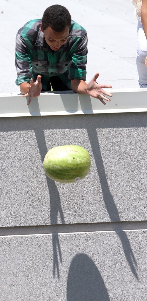 Rick Egan  | The Salt Lake Tribune
Jacob Hughes drops a watermelon from the roof of Copper Hills High, Friday, July 6, 2012. Students built devices in an attempt to catch watermelon as part of a science and physics grant the school received.