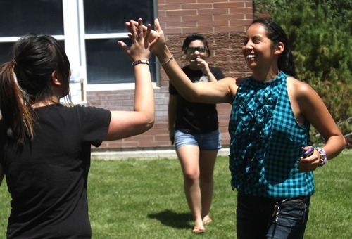 Rick Egan  | The Salt Lake Tribune 

Lyn Dao (left) high-fives Geovana Valazquez (right) as their watermelon was successfully dropped from the roof of Copper Hills High. Students built devices in an attempt to catch watermelons dropped from the roof of their school as part of a science and physics grant the school received.