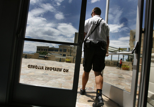 Scott Sommerdorf  |  The Salt Lake Tribune             
A security guard walks out of The Gateway Megaplex, Friday, July 20, 2012. The message on the door has been there prior to the mass shooting in Colorado.