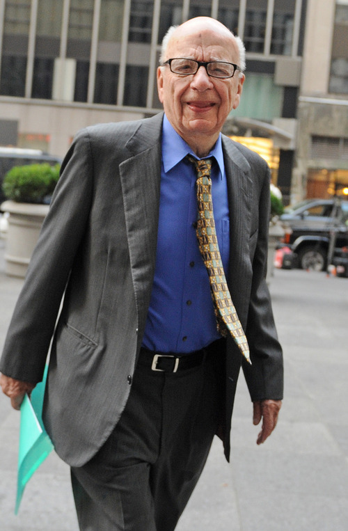FILE - In this July 22, 2011 file photo, Chairman and Chief Executive Officer of News Corporation Rupert Murdoch enters the News Corp. building, in New York. Media mogul Rupert Murdoch has resigned from a number of News Corp. subsidiary boards in Britain and the United States, a spokeswoman confirmed Saturday, July 21, 2012. (AP Photo/Louis Lanzano, File)