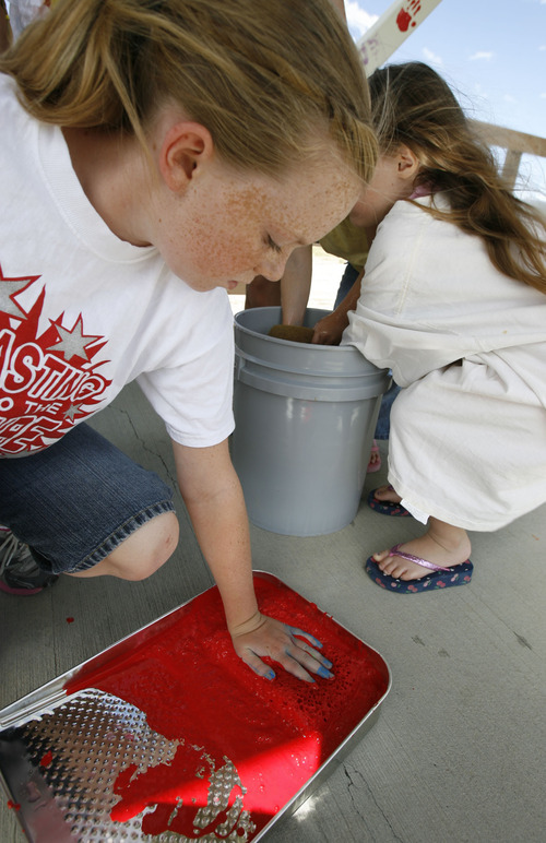 Francisco Kjolseth  |  The Salt Lake Tribune
Sydney Fisher, 12, goes for red during a community event to decorate a pedestrian bridge soon to be put in place for use by children at Sunset Ridge Middle School and Oakcrest Elementary.