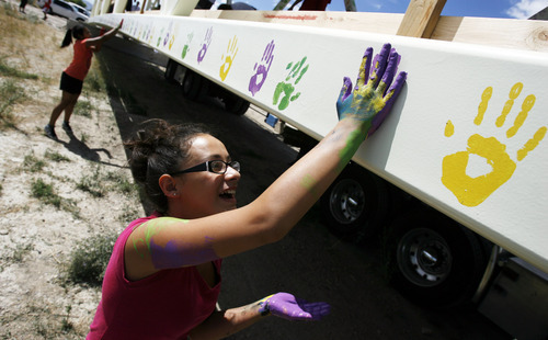 Francisco Kjolseth  |  The Salt Lake Tribune
Cirella Gonzales, 13, works the paint, marking the span of a pedestrian bridge on Thursday. Residents helped transportation officials decorate the walkway that soon will be placed at 8200 S. and U-111 to be used by students attending Sunset Ridge Middle School and nearby Oakcrest Elementary.