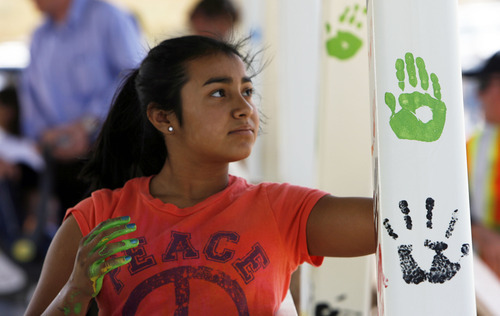 Francisco Kjolseth  |  The Salt Lake Tribune
Tatiana Olmedo, 12, makes her mark on a pedestrian bridge that was removed from Bangerter Highway and will soon find a home at 8200 S. U-111. The Utah Department of Transportation invited residents Thursday to join in handpaint printing on the recycled skywalk.