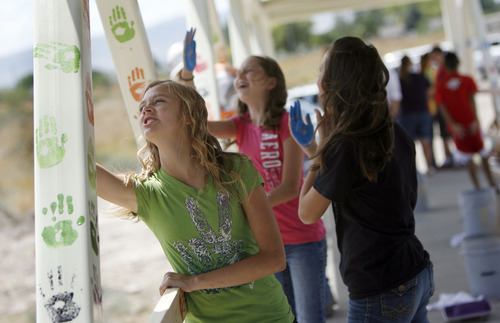 Francisco Kjolseth  |  The Salt Lake Tribune
Twelve year olds Amberly Lazenby, Lexi Olsen and Kambrea Zaragoza, from left, lend a hand in decorating a pedestrian bridge it plans to place at 8200 South and U-111.