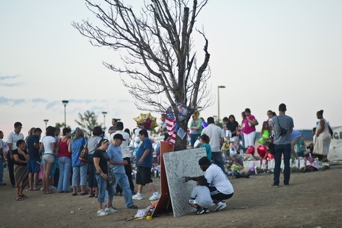 Chris Detrick  |  The Salt Lake Tribune
Family, friends and community members reflect at a memorial set up for the shooting victims at South Sable Blvd and East Centrepoint Drive in Aurora Thursday July 26, 2012. The site is covered with hundreds of balloons, candles, flowers, stuffed animals, rosaries and many other items people have left behind in remembrance of the victims.