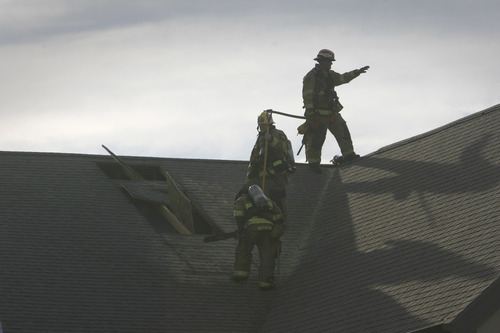 Rick Egan  | The Salt Lake Tribune 

Firefighters work on the roof of the Legacy Village care center in Kearns, to put out the hot spots, Monday, July 30, 2012.