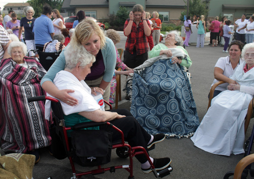 Rick Egan  | The Salt Lake Tribune 

Liz Allred comforts one of the residents of the Legacy Village care center in Kearns, Monday, July 30, 2012. The residents were all moved safely into the parking lot while the firefighters put out the fire.