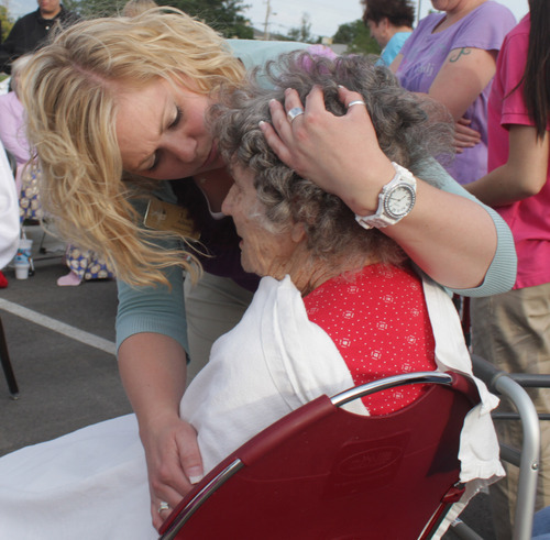 Rick Egan  | The Salt Lake Tribune 

Employee Liz Allred, comforts one of the residents of the Legacy Village care center in Kearns, Monday, July 30, 2012. The residents were all moved safely into the parking lot while the firefighters put out the fire.