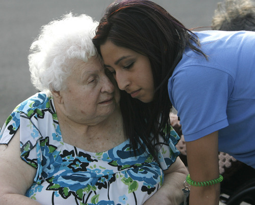 Rick Egan  | The Salt Lake Tribune 

An employee comforts one of the residents of the Legacy Village care center in Kearns, Monday, July 30, 2012. The residents were all moved safely into the parking lot while the firefighters put out the fire.