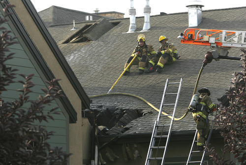 Rick Egan  | The Salt Lake Tribune 

Firefighters work on the roof of the Legacy Village care center in Kearns, to put out the hot spots, Monday, July 30, 2012.