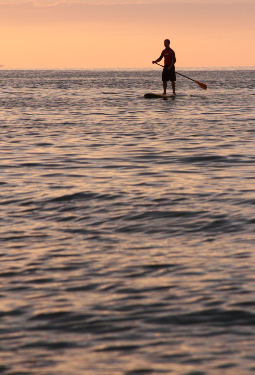 Francisco Kjolseth  |  The Salt Lake Tribune
Steve Mayer of Draper enjoys the end of the day on a paddle board near the Great Salt Lake marina on Thursday, July 5, 2012. When he isn't on the water, Mayer is often in the sky paragliding for Cloud 9 Toys.