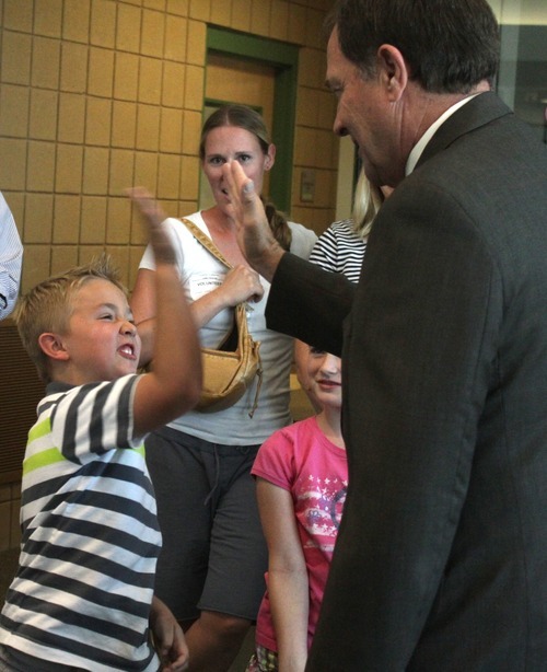 Rick Egan  | The Salt Lake Tribune 

Second Grader, Cameron Scott, high-five's Gov. Herbert after he read to the second grade students at Foxboro Elementary, in North Salt Lake, Tuesday, July 31, 2012.  Gov. Herbert and leaders of Prosperity 2020 announced an initiative to get more business volunteers in schools.