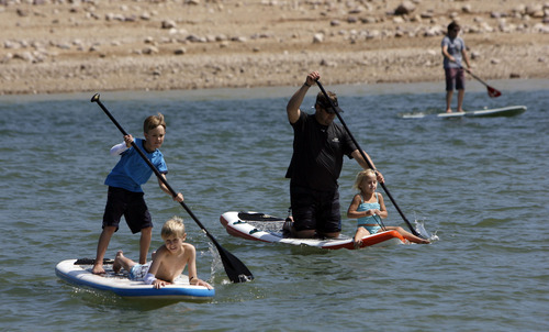 Francisco Kjolseth  |  The Salt Lake Tribune
Rob Bolding, center, with Red Mountain Outfitters in St. George takes his daughter Erika, 6, for a demo spin as his son Seth, 11, gets a ride from friend Jake Everett, 10, as the Open Air Demo Day takes to the water kicking off the Outdoor Retailer Summer Market at Jordanelle State Park on Wednesday, August 1, 2012. More than 150 outdoor brands and many more retailers are at the reservoir to show off and experience first-hand the new gear coming out for the summer of 2013. More than 27,000 are expected to attend the twice a year convention held at the Salt Palace Convention Center which runs Aug. 2-5.