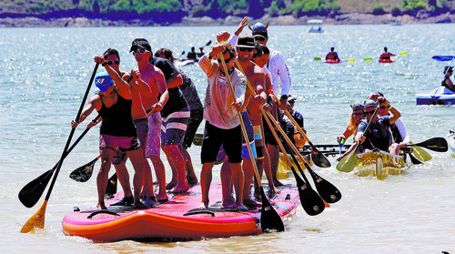 Francisco Kjolseth  |  The Salt Lake Tribune
Supzilla momentarily takes the lead before being over run by the King Kong canoe as the Open Air Demo Day took to the water kicking off the Outdoor Retailer Summer Market at Jordanelle State Park on Wednesday, August 1, 2012. More than 150 outdoor brands and many more retailers are at the reservoir to show off and experience first-hand the new gear coming out for the summer of 2013. More than 27,000 are expected to attend the twice a year convention held at the Salt Palace Convention Center which runs Aug. 2-5.