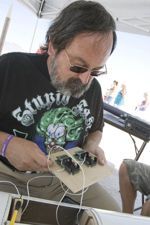 Paul Fraughton | Salt Lake Tribune
Ron Weigel works on the electronics  that measures the altitude of the rocket and deploys its parachute at the rockets apogee. The event was Utah Rocket Club's Hellfire 2012, an annual rocket launch  held on the Bonneville Salt Flats near Wendover.
 Friday, August 3, 2012