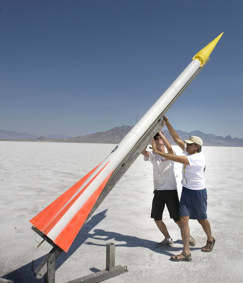Paul Fraughton | Salt Lake Tribune
Tobin Yehle, 19, and his father, Jim Yehle, right, push their rocket into position on the launching pad at the Utah Rocket Club's Hellfire 2012, an annual rocket launch  held on the Bonneville Salt Flats near Wendover.
 Friday, August 3, 2012