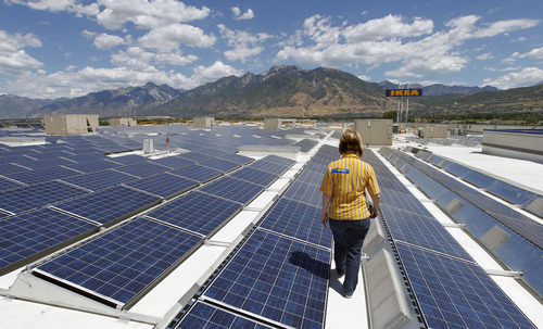 Al Hartmann  |  The Salt Lake Tribune  
Celeste Ledesma, marketing and public relations officer for Ikea walks through some of the hundreds of solar panels installed on the store's roof in Draper on Thursday July 26.   The solar energy system is up and running.  The company bills the array as the state's largest private commercial solar project. The 180,500-square-foot photo voltaic array consists of a 1,015 kw system built with 4,228 panels.