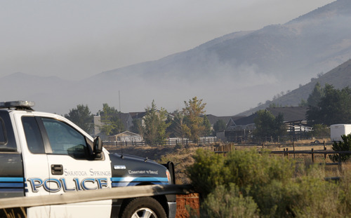 Al Hartmann  |  The Salt Lake Tribune  
Eagle Mountain police guard the North Ranch neighborhood while it was still under evacuation Tuesday morning Aug. 8 as the Pinyon Fire continued to burn in the mountains on Camp Williams land to the north. The evacuation order was lifted shortly afterward.