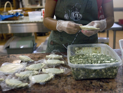Kim Raff | The Salt Lake Tribune
Ana Valdemoros wraps spinach empanadas in the kitchen of Martin's Fine Desserts in Salt Lake City on August 3, 2012.