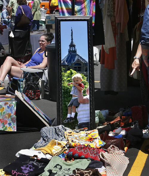 Scott Sommerdorf  |  Tribune file photo             
Shoppers are reflected in a mirror at a vendor's booth selling clothing at the opening day of the Urban Flea Market in Salt Lake City in June.  The marketplace is open the second Sunday of every month through October at 400 S. State St.