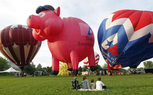 Al Hartmann  |  The Salt Lake Tribune  
Folks watch as balloons fill and rise in the mass sunrise ascension from Storm Mountain Park in Sandy Friday morning for the The Sandy Balloon Festival. The festival continues with a ballon glow Saturday evening at the South Towne Promenade in front of Sandy City Hall.