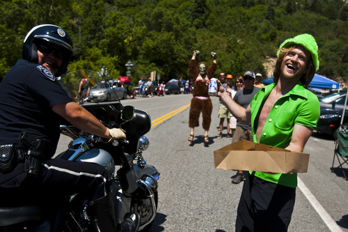 Chris Detrick  |  The Salt Lake Tribune
Leprechaun Mark Robinson, of Salt Lake City, offers a beer and doughnuts to a police officer as he patrols Little Cottonwood Canyon during the Ultimate Challenge presented by Larry H. Miller Tour of Utah Saturday August 11, 2012. The traditional 100-mile route features 9,456 feet of climbing and a summit finish at Snowbird Ski and Summer Resort