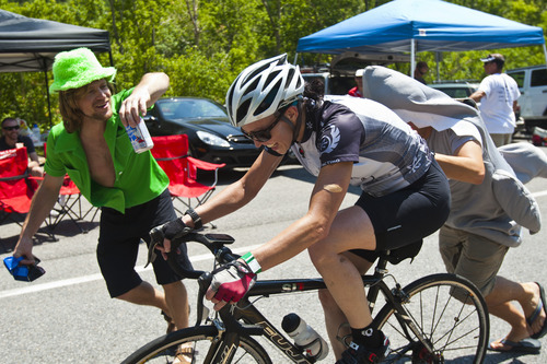 Chris Detrick  |  The Salt Lake Tribune
Leprechaun Mark Robinson, of Salt Lake City, offers a beer to a biker as she races up Little Cottonwood Canyon with the help of Shark Nate Friedman, of Salt Lake City, during the Ultimate Challenge presented by Larry H. Miller Tour of Utah Saturday August 11, 2012. The traditional 100-mile route features 9,456 feet of climbing and a summit finish at Snowbird Ski and Summer Resort