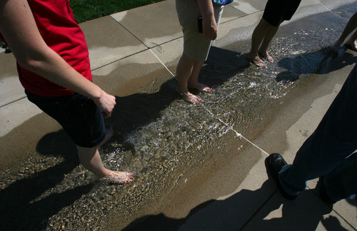 Steve Griffin | The Salt Lake Tribune
People enjoy the water feature at the new Fairbourne Station Promenade, a four-acre park behind West Valley City Hall, on Thursday. The park has an interactive scale, a pavilion with a shade structure and pedestrian and bike-friendly walkways.