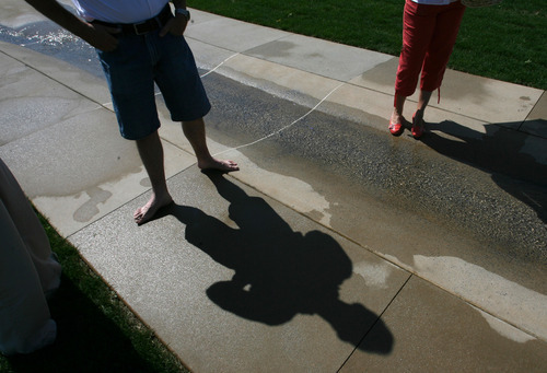 Steve Griffin | The Salt Lake Tribune

West Valley City mayor Mike Winder enjoys the water feature at the the Promenade, which was dedicated Thursday at Fairbourne Station. The Promenade is a key element of Fairbourne Station, an urban renewal project designed to be a centerpiece for West Valley City.