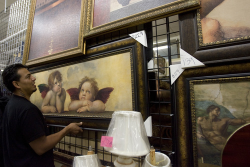 Kim Raff | The Salt Lake Tribune
Luis Romero hangs a painting at the Ester's Family Furniture store at the Salt Lake Indoor Swap Meet in West Valley City on July 21, 2012.