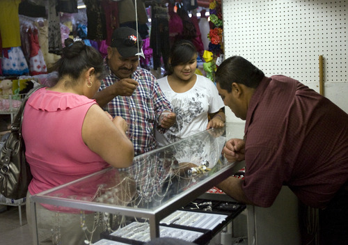 Kim Raff | The Salt Lake Tribune
(from left) Jacinta, Manuel and Zayra Luna look at jewelry in a store in the Salt Lake Indoor Swap Meet in West Valley City on July 21, 2012.