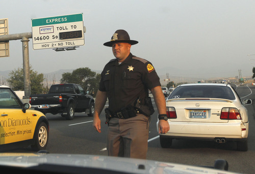 Al Hartmann  |  The Salt Lake Tribune  
Utah Highway Patrol Trooper Emery Calkins pulls over a driver with out-of-state plates as he patrols I-15 in Utah County Thursday morning. He was on the lookout for motorists violating express-lane rules. This driver was driving with no passengers -- a no-no except those who pay a special toll.