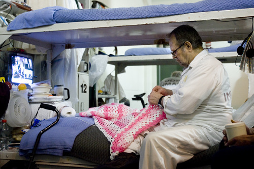 Kim Raff | The Salt Lake Tribune
Anthony Liebhard, 75, crochets a blanket in his bunk in the ADA unit at the Lone Peak Prison facility in Draper, Utah on July 26, 2012. The prison has created a separate unit with in the prison to provide care for geriatric prisoners.