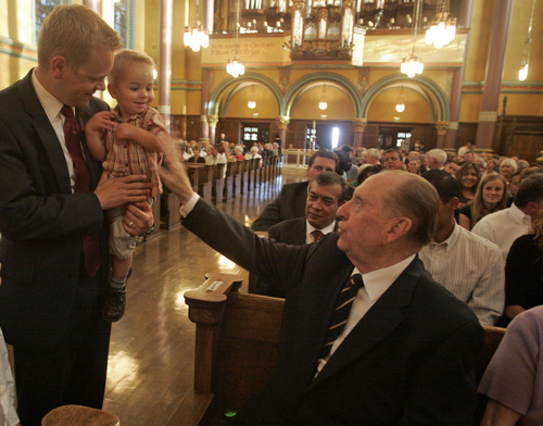 LDS Church President Thomas S. Monson visits with Scott Daw of Herriman and Daw's 1-year-old son, Brennan Daw. Jim Urquhart/The Salt Lake Tribune