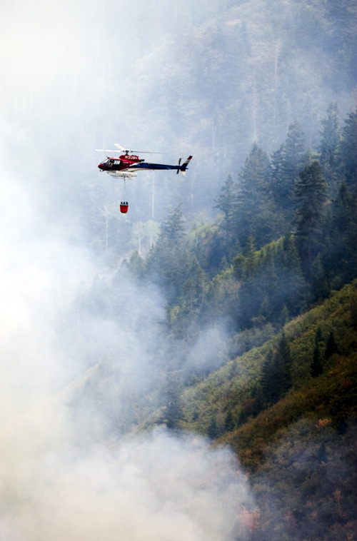 Kim Raff | The Salt Lake Tribune
Helicopters dump water on a wildfire off Highway 40 outside of Heber in Wasatch County,Utah on August 19, 2012.