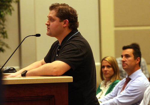 Leah Hogsten  |  The Salt Lake Tribune
John Dayton, (left) speaks in favor of Marci and Andrew Kelley's (seated, right) request to amend his Corner Canyon subdivision plan at Draper City Hall council chambers August 21, 2012. Dayton was able to install a bright blue-and-red basketball court after his successful appeal to the City Council to lift a landscaping and development restriction in February that neighbors feel ruins the scenery. The Kelley's undeveloped lot is three lots north of Dayton.