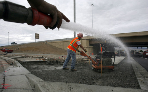 Francisco Kjolseth  |  The Salt Lake Tribune
Julio Martinez waters down the ground for Kyle Graham as he uses a plate compactor along the I-15 CORE project at the Orem Center Street exit on Wednesday. The $1.7 billion project stretches from Lehi to Spanish Fork in Utah County.