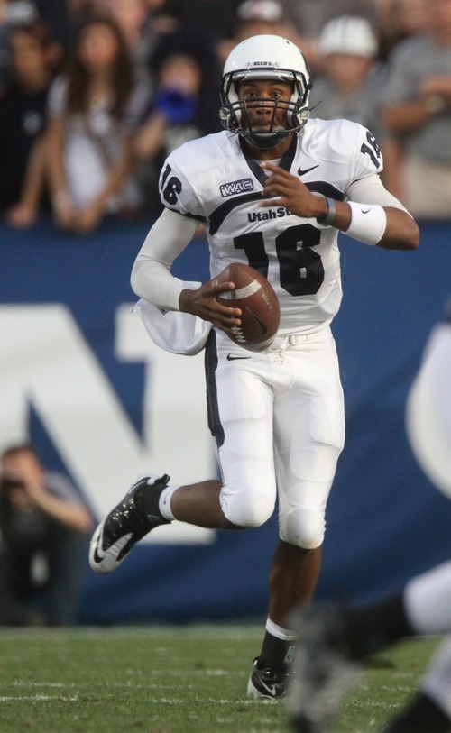 Rick Egan  | The Salt Lake Tribune 

Utah State Aggies quarterback Chuckie Keeton (16) looks for a receiver for the Aggies in football action, BYU vs Utah State,  in Provo, Friday, September 30, 2011.
