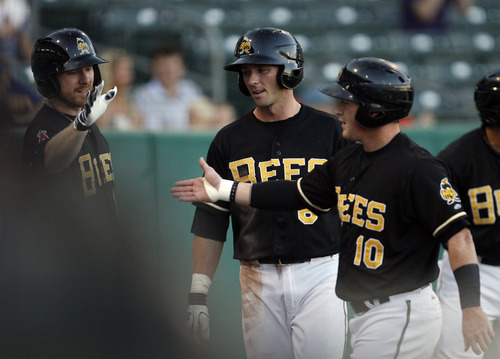 Rick Egan  | The Salt Lake Tribune 

 Salt Lake's  Andrew Romine (6) and Kole Calhoun (10) are greeted as after they scored two early runs for the Bees in the first inning, in baseball action, Salt Lake vs, the Tucson Padres, at Springmobile Ballpark, Monday, August 27, 2012.