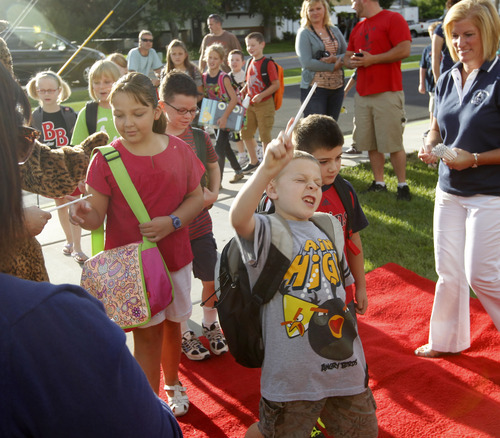 Al Hartmann  |  The Salt Lake Tribune
Canyon School District Butler Elementary School students walk down a red carpet to enter the front doors of the school Monday. They passed by cheering teachers, staff members and the school's Bobcat mascot in a lively welcome back to school.