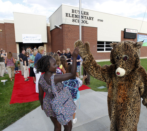 Al Hartmann  |  The Salt Lake Tribune
Canyon School District Butler Elementary School students get a high five from the Bobcat school mascot as they walk down a red carpet to enter the front doors of the school Monday.  They passed by cheering teachers, staff members and the school's Bobcat mascot in a lively welcome back to school.