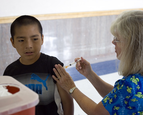 Kim Raff  |  The Salt Lake Tribune
 Joseph Porta receives a vaccination from Donna Jaco, a registered nurse from Community Nursing Services, during an immunization clinic at Brockbank Junior High School in Magna, Utah on August 15, 2012. With money from the state Department of Human Services, Salt Lake County is creating a health clinic at Brockbank to treat the physical and mental health needs of the community.