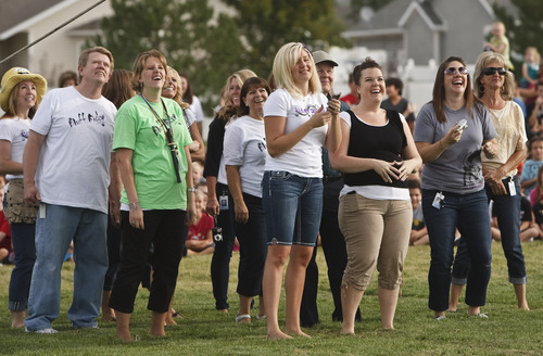 Leah Hogsten  |  The Salt Lake Tribune
Bluff Ridge Elementary School teachers and staff giggle as their fellow employees ride in the hot air balloon Thursday. Students at the Syracuse school enjoyed a lesson about the aerodynamics of hot air balloon flying.