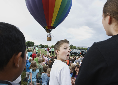 Leah Hogsten  |  The Salt Lake Tribune
Alex Black, fifth-grader at  Bluff Ridge Elementary School, reacts to seeing one of his teachers flying up and away on a short balloon ride. Students at the Syracuse school enjoyed a lesson about the aerodynamics of hot air balloon flying.