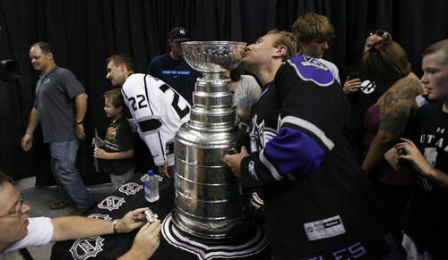 Francisco Kjolseth  |  The Salt Lake Tribune
Michael Weaver, of Kaysville, sneaks in a kiss on the Stanley Cup as Trevor Lewis, who played hockey for Brighton High School, brings the Stanley Cup home for a day as a member of the NHL champion Los Angeles Kings. Thousands of fans lined up at the Maverik Center in West Valley City on Thursday, August 30, 2012, for a chance to pose for a picture with Lewis and the Cup.
