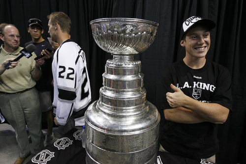 Francisco Kjolseth  |  The Salt Lake Tribune
Sam Taylor, 17, of Salt Lake City, gives the thumbs up as he sneaks in for a picture while Trevor Lewis, who played hockey for Brighton High School, is interviewed by the media Thursday at the Maverik Center. Lewis brought the Stanley Cup home for a day as a member of the NHL champion Los Angeles Kings. Thousands of fans lined up at the Maverik Center in West Valley City for a chance to pose for a picture with Lewis and the Cup.