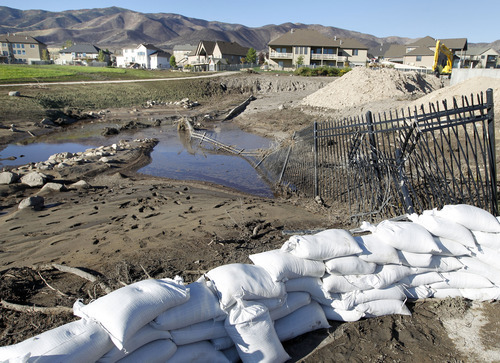 Al Hartmann  |  The Salt Lake Tribune
Sandbags still line the flood-retention basin in the Jacobs Ranch subdivision in Saratoga Springs on Tuesday, Sept. 4.  The basin is full of mud from Saturday's flash flood and mud flow.