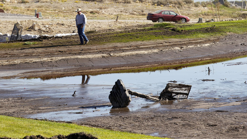 Al Hartmann  |  The Salt Lake Tribune
A man walks around a clogged flood-retention basin in the Jacobs Ranch subdivision in Saratoga Springs on Tuesday, Sept. 4.