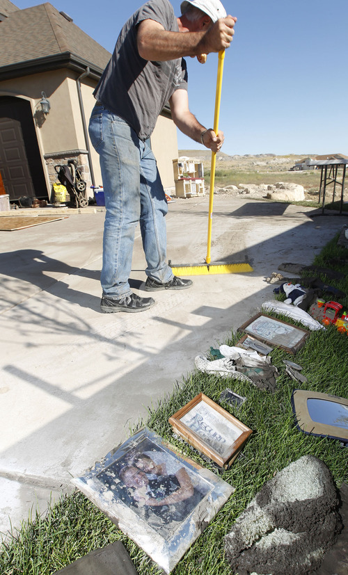 Al Hartmann  |  The Salt Lake Tribune
Family and friends of Gavin and Krisha McClellan help sort and remove flood-damaged belongings at his home in the Jacobs Ranch subdivision in Saratoga Springs on Tuesday, Sept. 4. In the foreground is their mud-damaged wedding picture, which is a loss and will be thrown away.